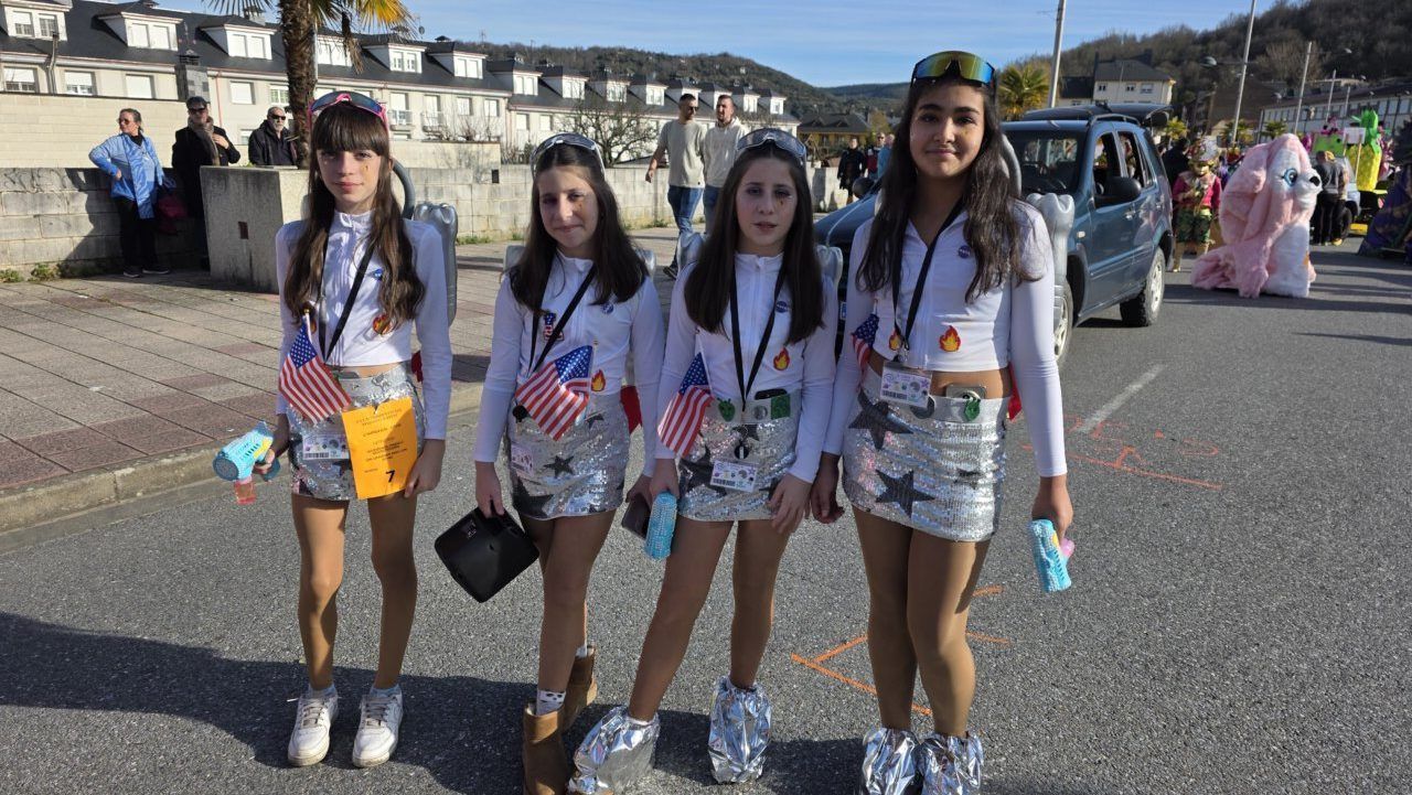 Cuatro niñas vestidas con trajes brillantes en el desfile de carnaval en Toreno