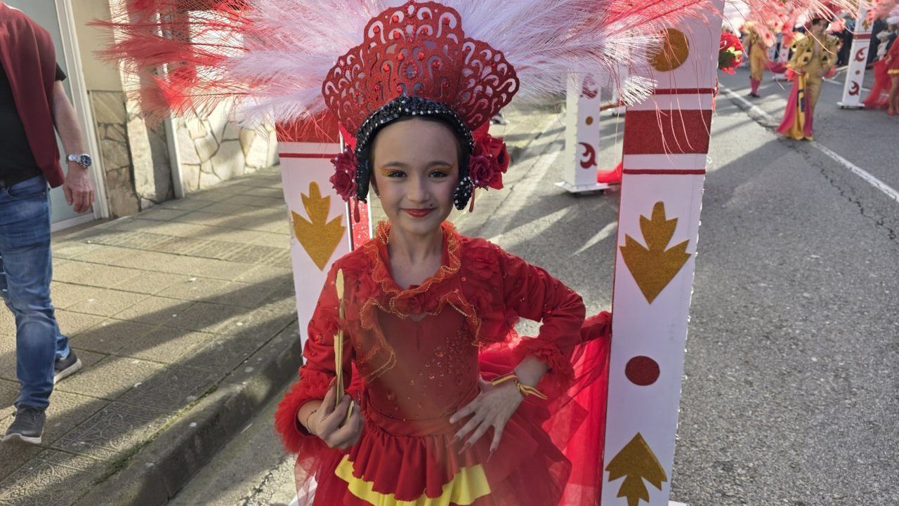 Niña con disfraz rojo y plumas en el Carnaval de Toreno