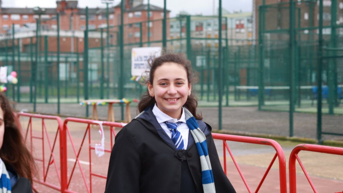 Niña sonriendo en el carnaval de Ponferrada con fondo de canchas