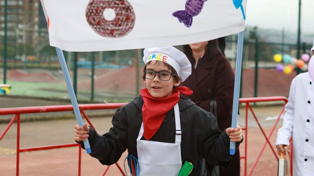 Niño disfrazado de chef sosteniendo una bandera en el carnaval