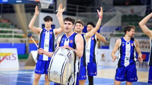 Jugadores de baloncesto celebrando en la cancha con un tambor.