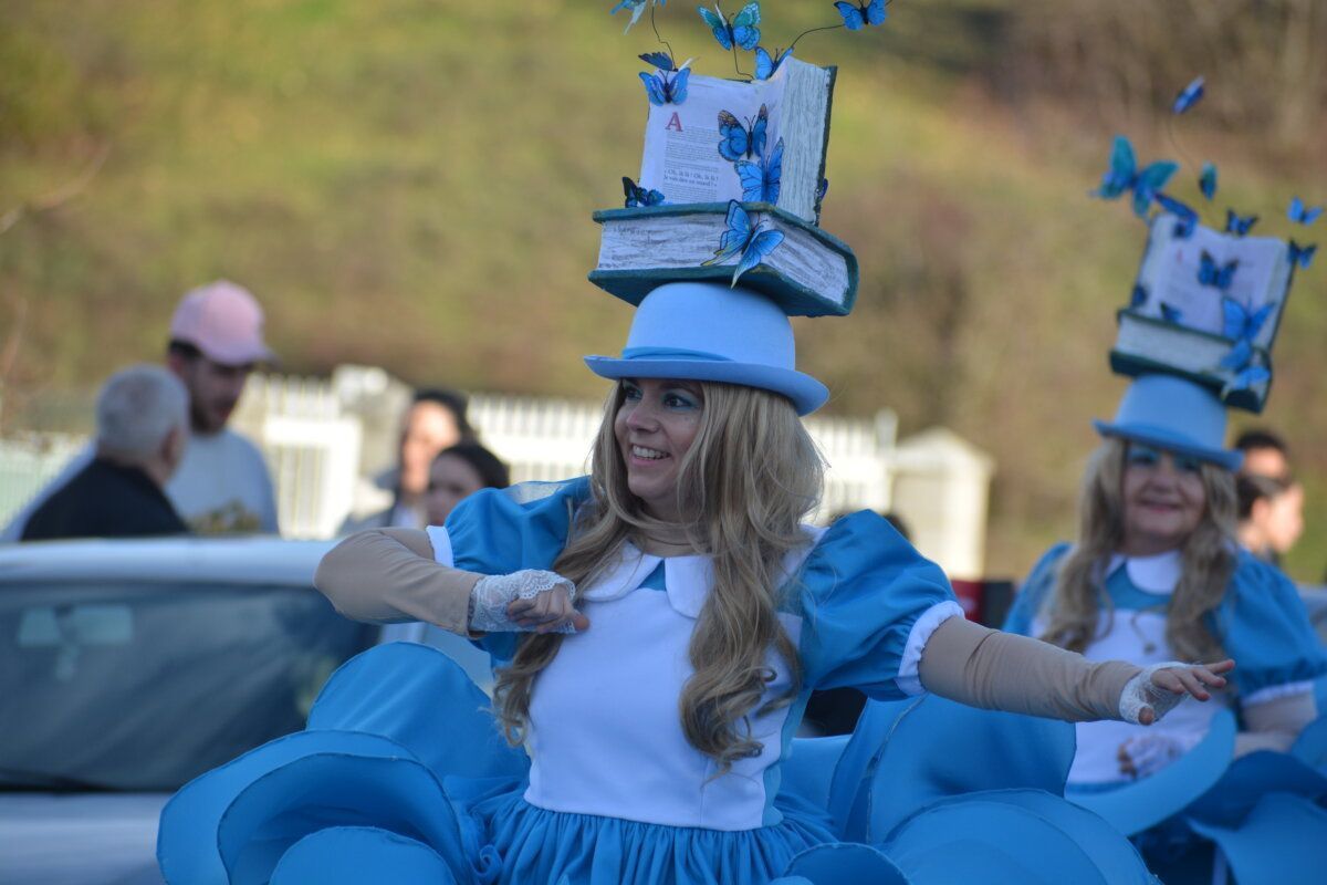 Mujer con vestido azul y sombrero decorado en desfile de Carnaval