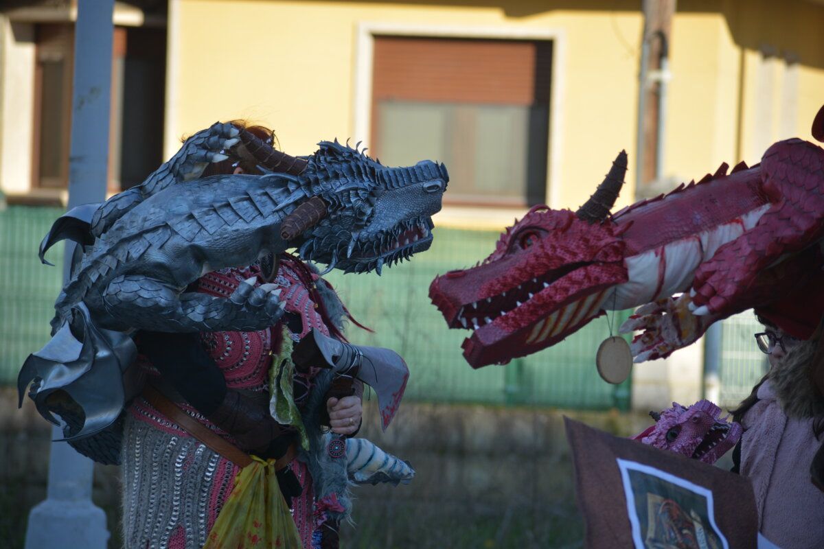 Personas disfrazadas con cabezas de dragón en desfile de carnaval