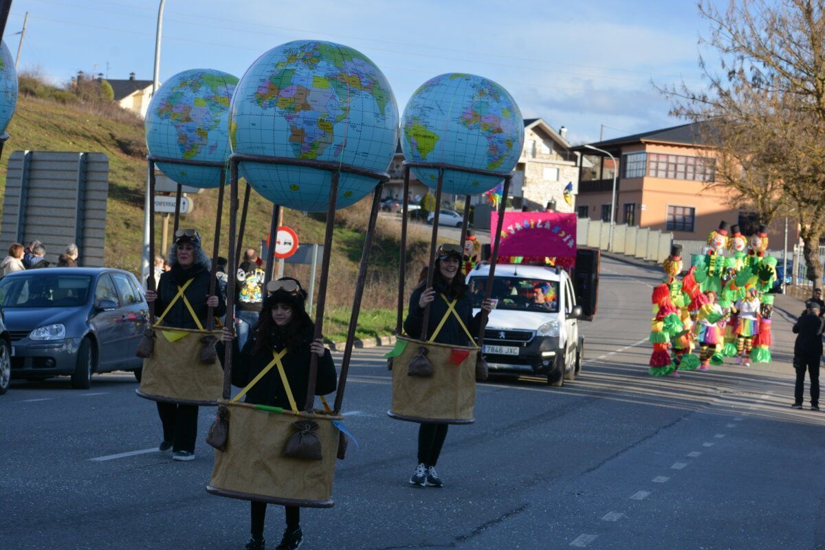Participantes del desfile de carnaval en Cacabelos con globos terráqueos