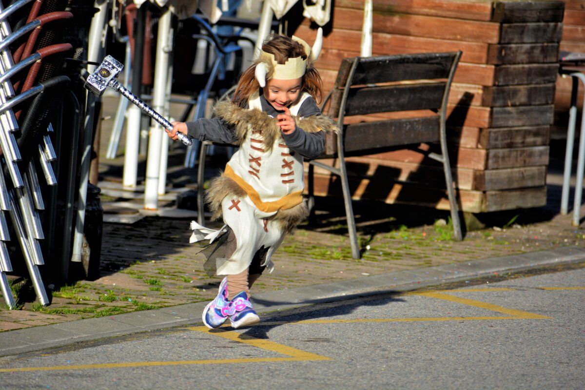 Niña disfrazada corriendo en el desfile de Carnaval