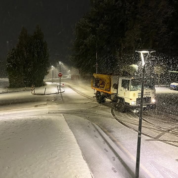 Camión de limpieza en una calle nevada durante la noche en León