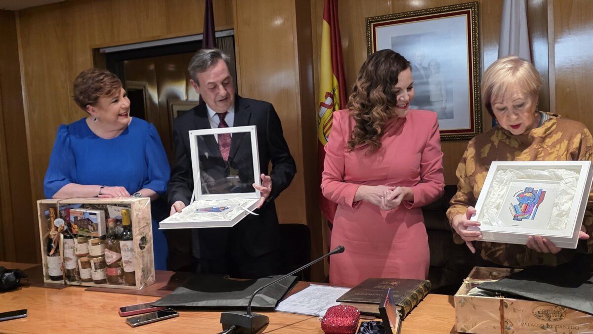 Cuatro personas sosteniendo regalos en un evento del festival del botillo