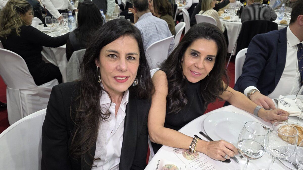 Dos mujeres sonrientes en una mesa durante el festival del botillo en Bembibre