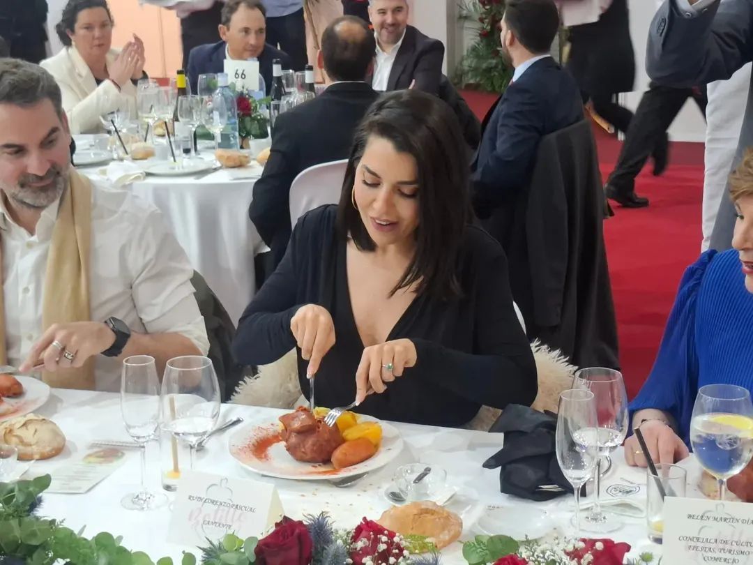 Una mujer sirviendo botillo en una mesa del Festival del Botillo