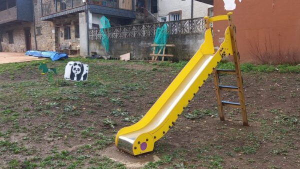 Tobogán amarillo en un parque infantil de Bouzas con decoraciones