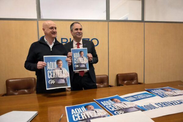 Julio Arias y Neftalí Fernández sosteniendo carteles del PP en Ponferrada