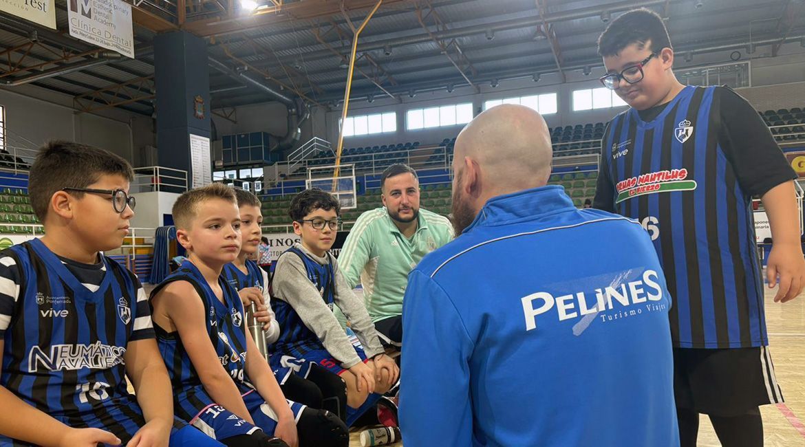 Entrenador hablando con jóvenes jugadores de baloncesto en un gimnasio