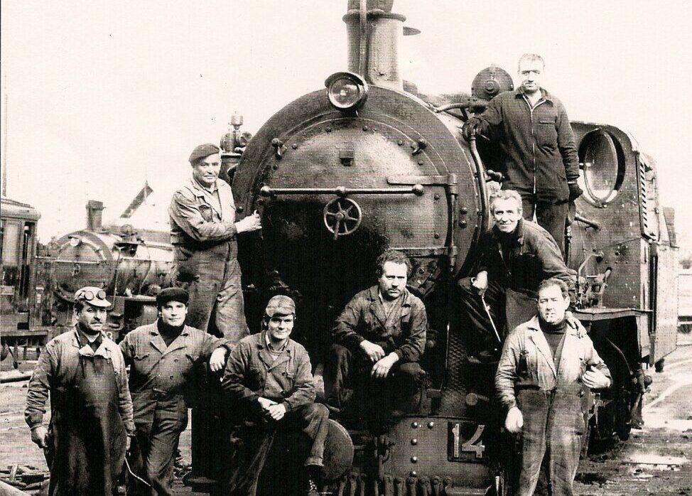 Grupo de trabajadores junto a una locomotora de vapor del ferrocarril de la MSP