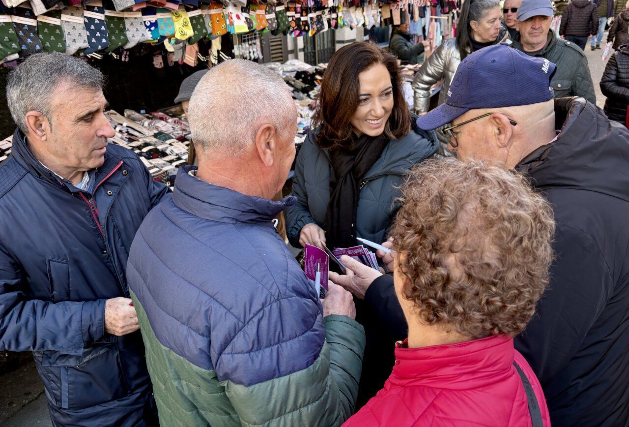 Grupo de personas interactuando en un mercado en La Bañeza