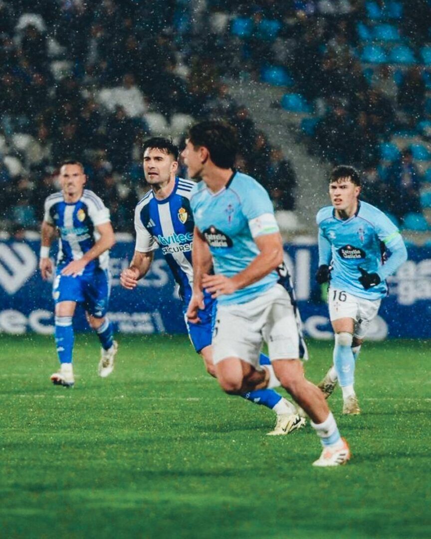 Jugadores de Ponferradina y Celta en un partido de fútbol bajo la lluvia