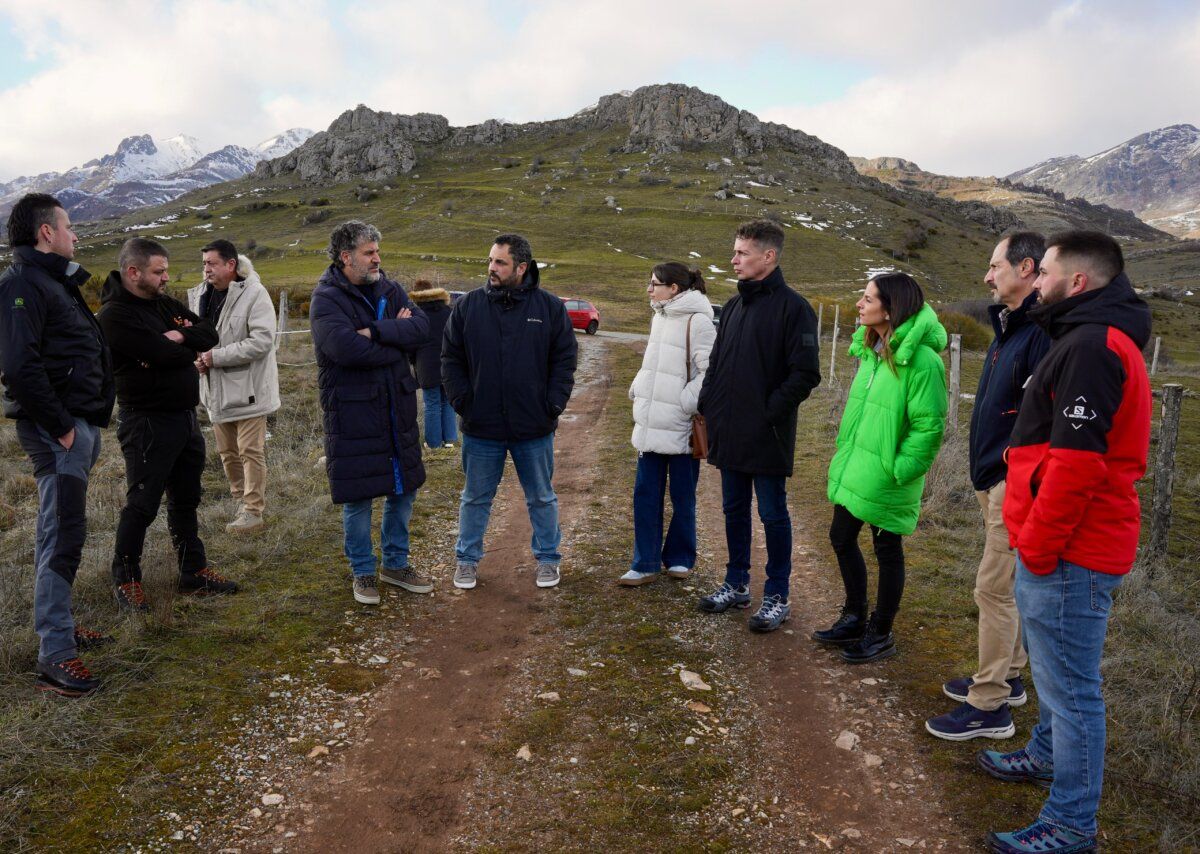 Reunión de ganaderos en un paisaje montañoso con participantes conversando.