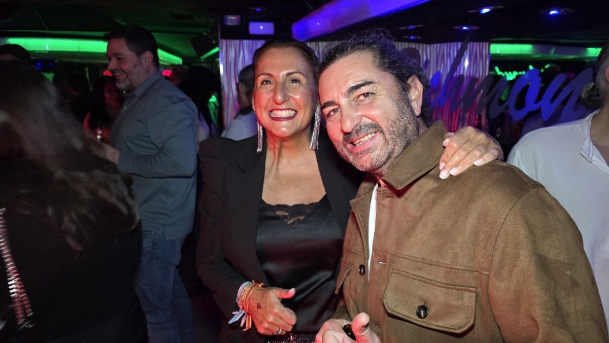 Pareja sonriendo en una fiesta con luces de colores