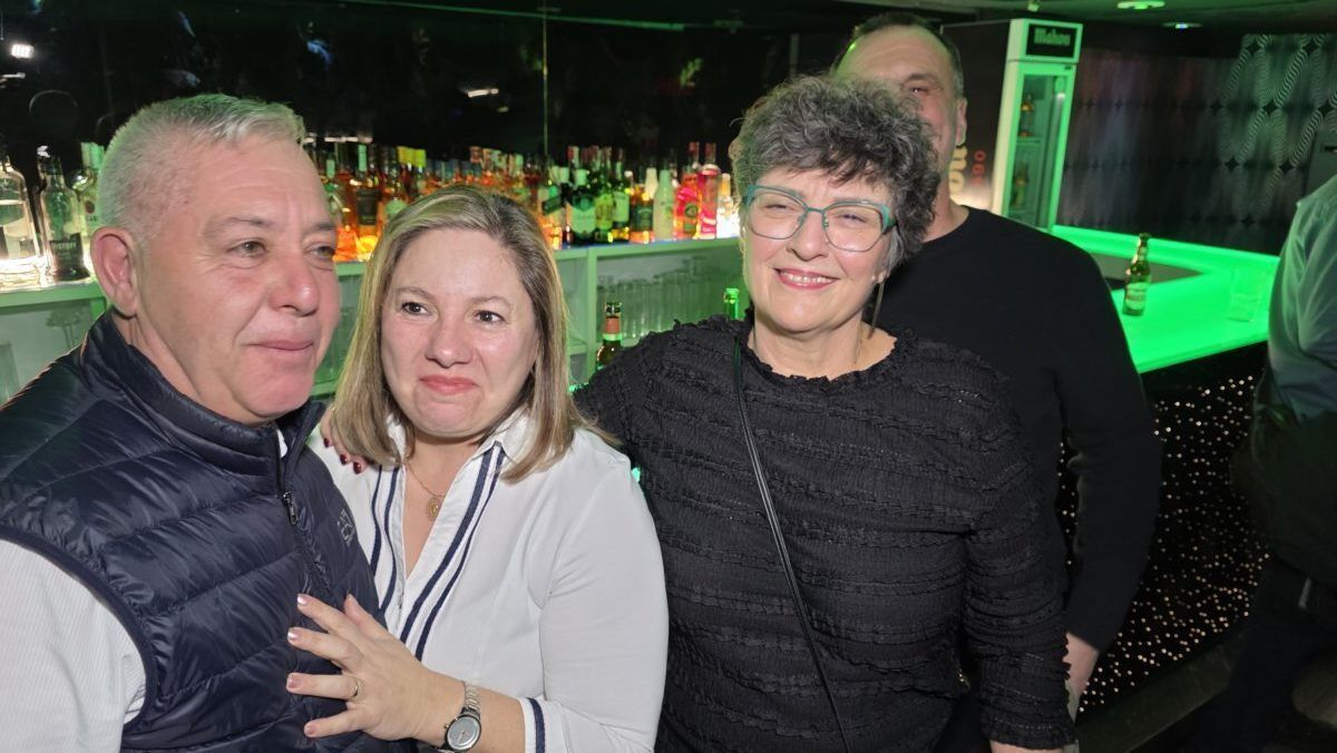 Grupo de amigos disfrutando en una fiesta con bebidas de fondo