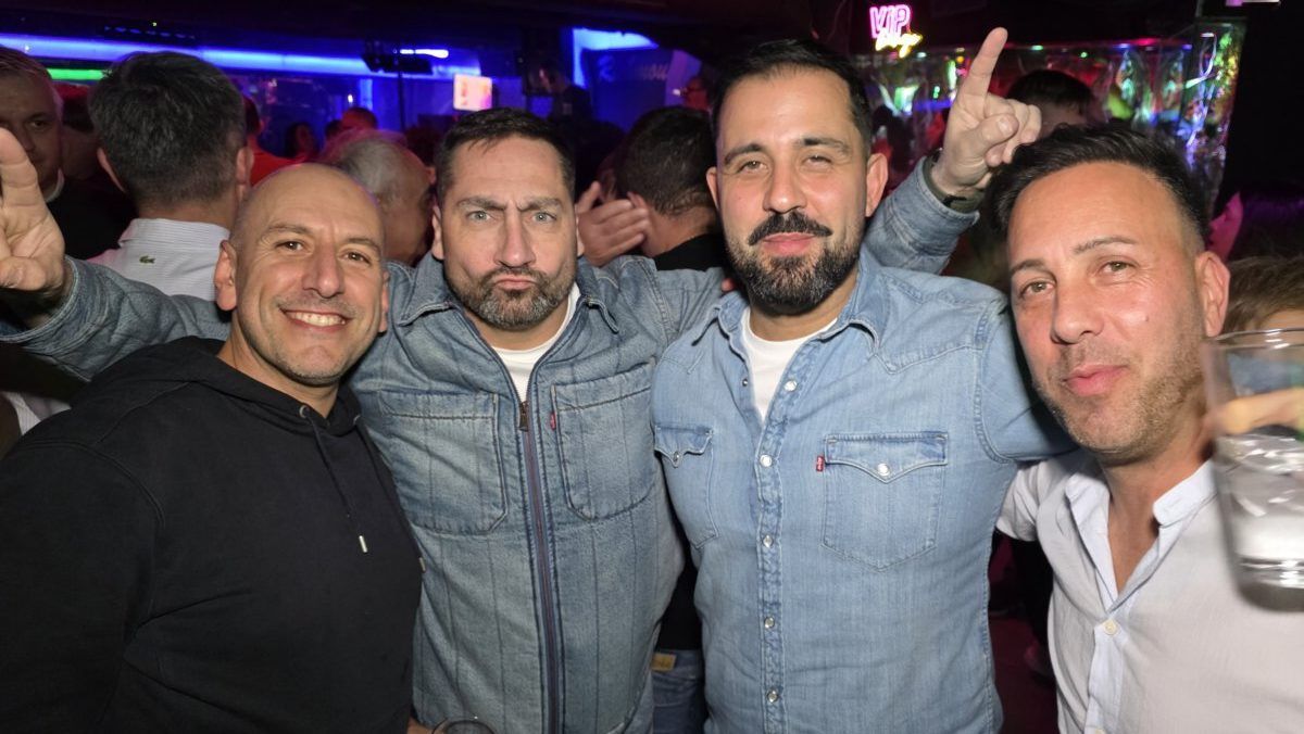 Cuatro amigos posando en una fiesta con ambiente festivo