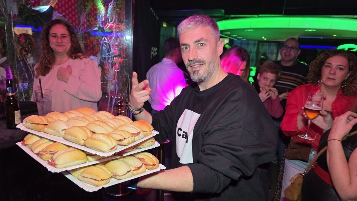 Hombre sirviendo bocadillos en una fiesta animada