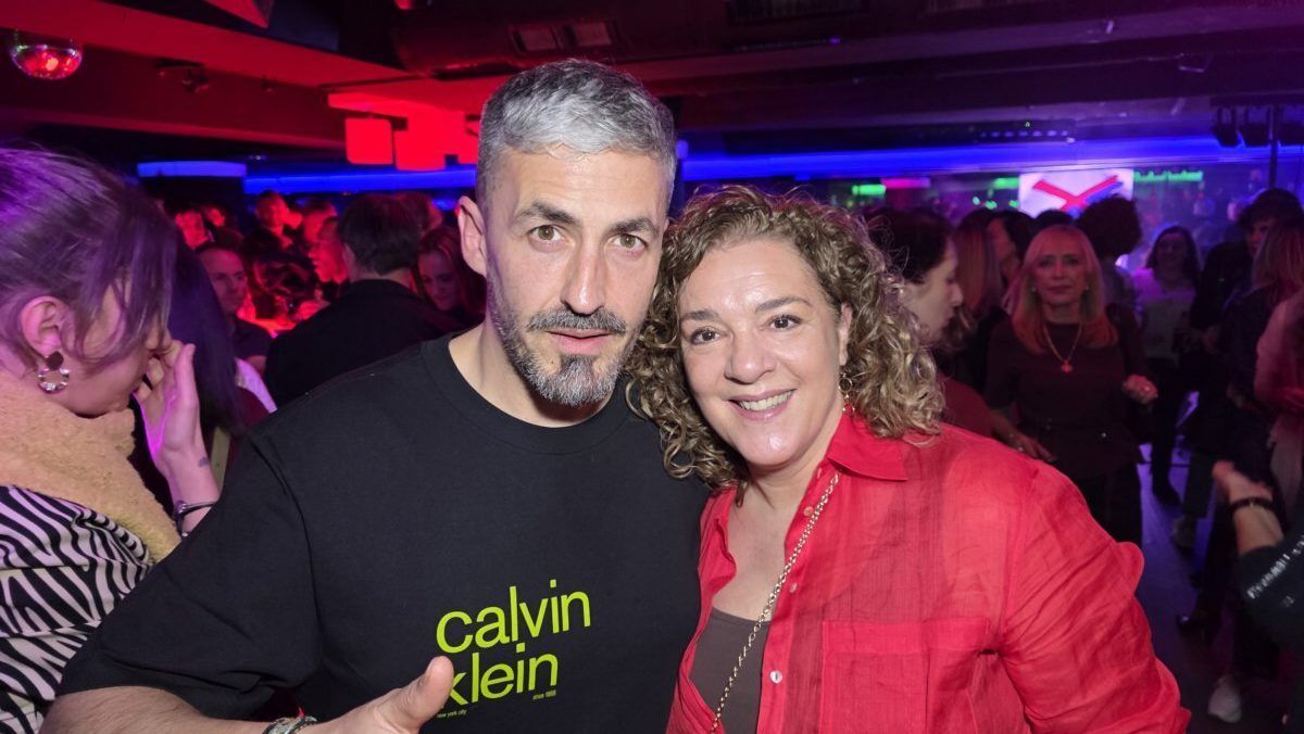 Dos personas posando en una fiesta con luces de colores