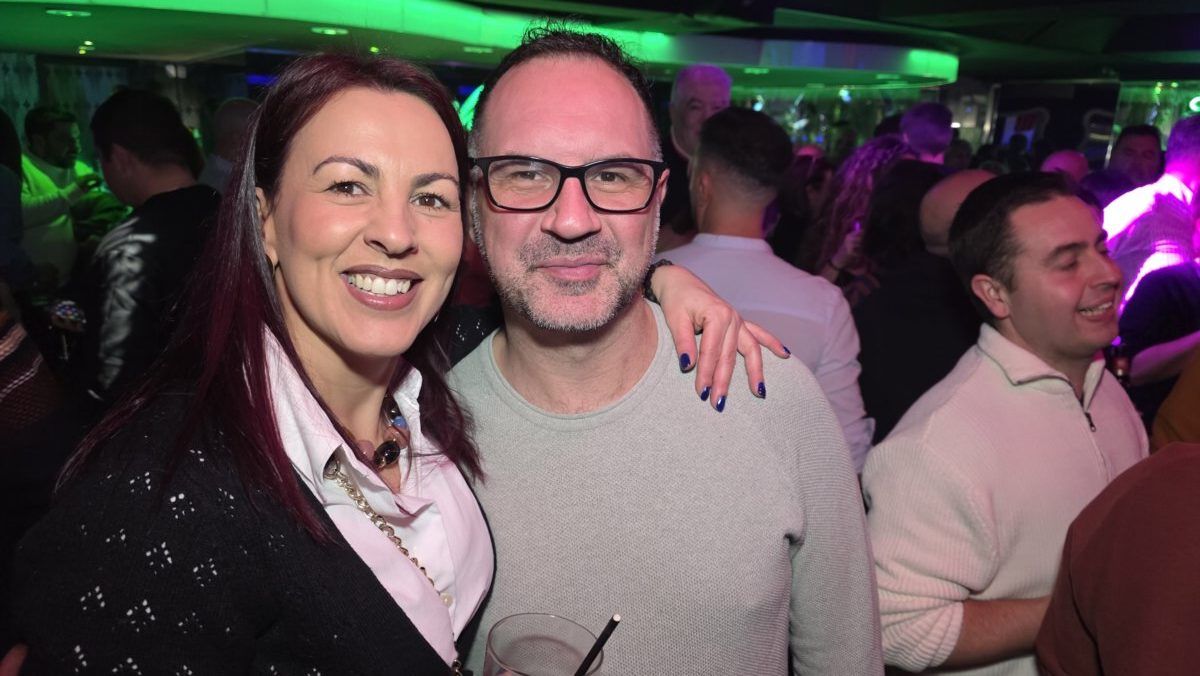 Pareja sonriente en una fiesta con luces de colores