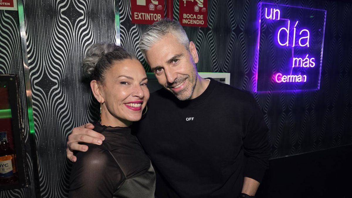 Pareja sonriendo en una fiesta con luces de neón