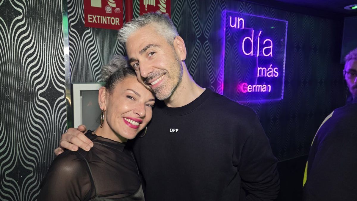 Pareja sonriendo en una fiesta con luces de neón