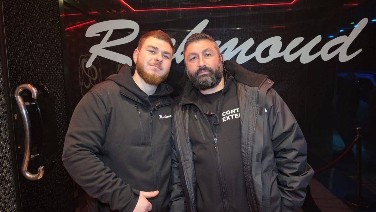 Dos hombres posando frente al letrero de Richmond.