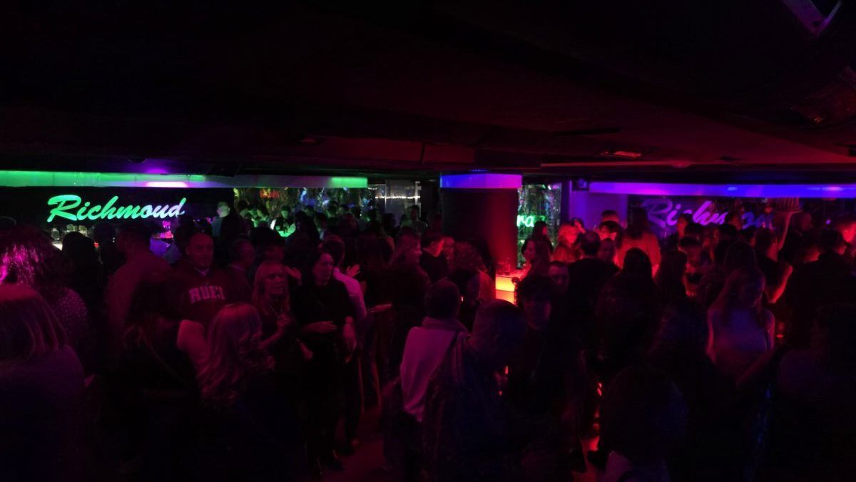 Multitud disfrutando en el club Richmond con luces de colores