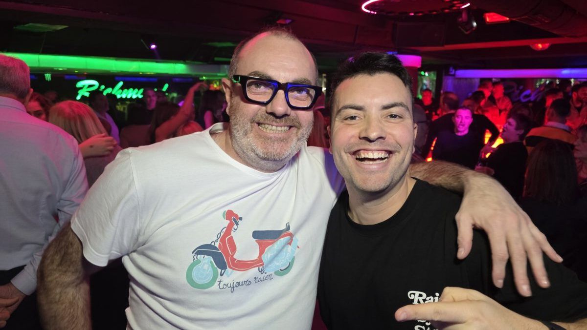 Dos hombres sonrientes en una fiesta en Richmond con luces de colores