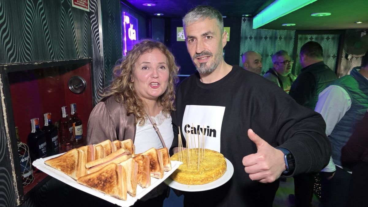 Pareja sosteniendo platos de comida en un evento festivo