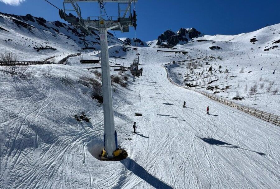 Esquiadores en la estación de esquí San Isidro con nieve y telesillas