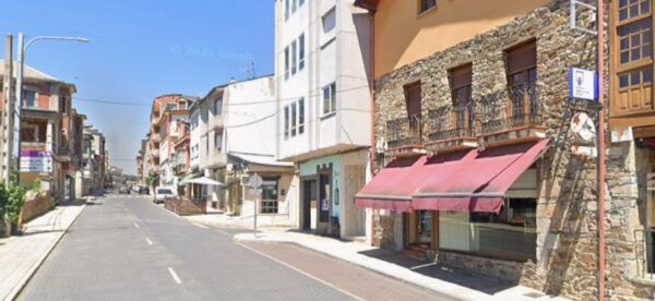 Vista de una calle en Toral de los Vados con edificios y un establecimiento