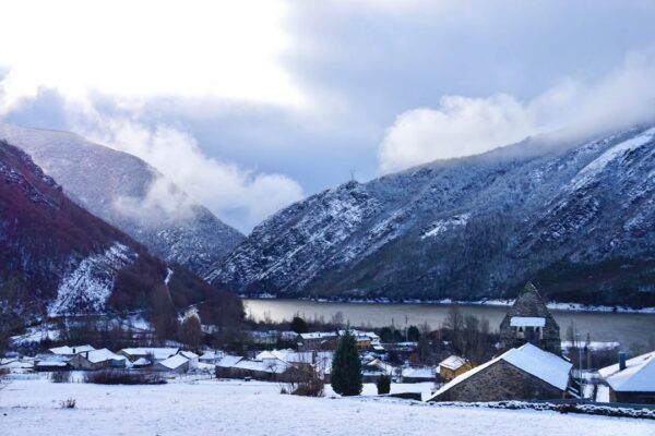 Vista del Valle de Laciana cubierto de nieve con montañas y casas