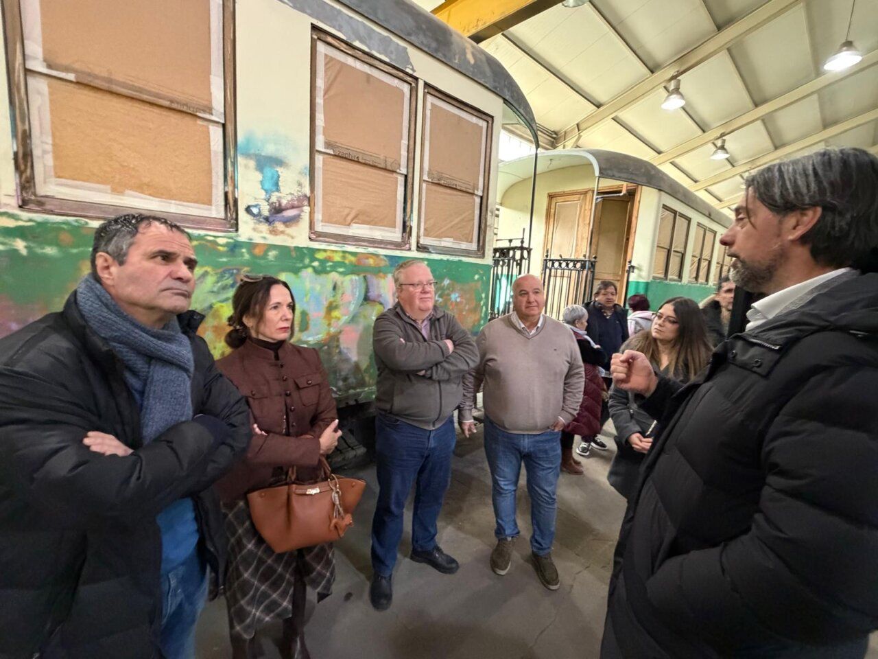 Grupo de personas en un taller de reparación de ferrocarriles