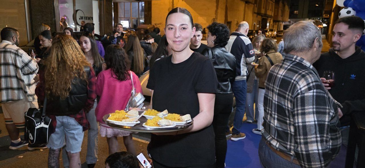 Una mujer sirviendo platos en la inauguración del Bar Sueños en Ponferrada.