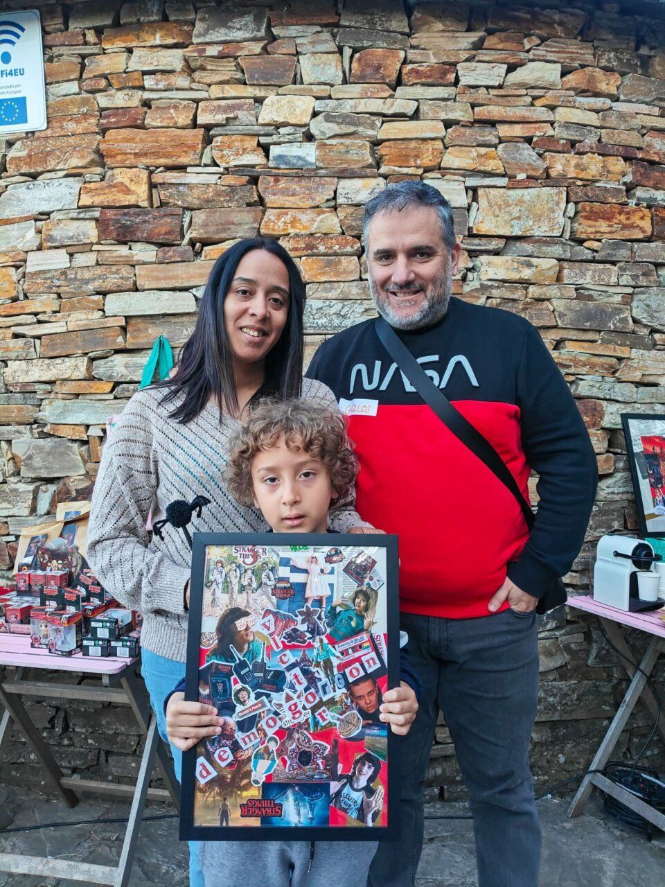 Familia posando con un collage de Stranger Things en Carracedelo