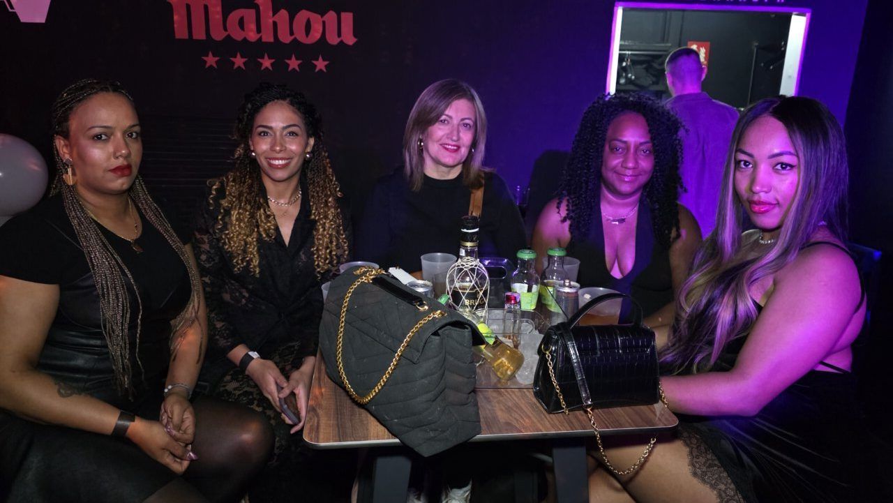 Grupo de mujeres disfrutando en un bar durante el concierto de Dalvin La Melodía