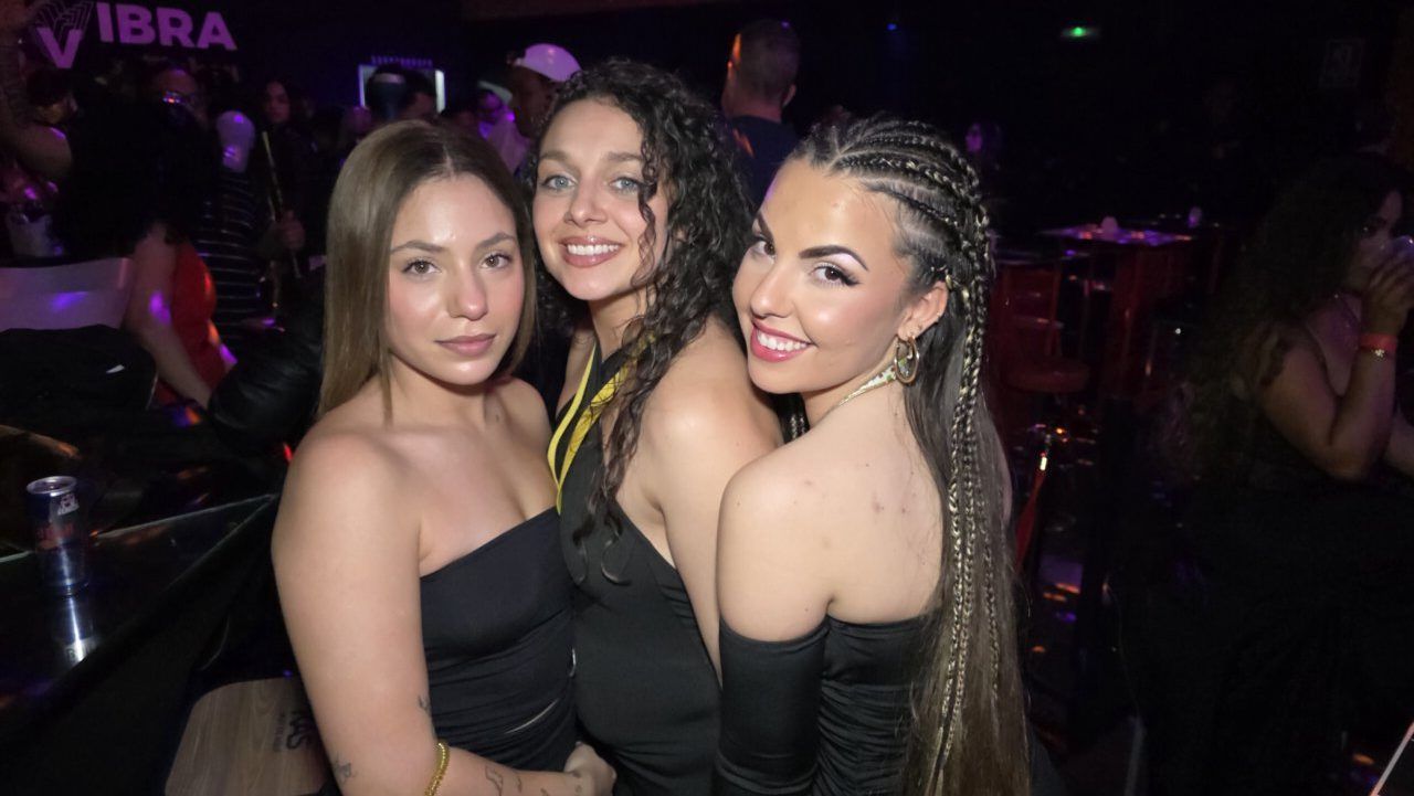 Tres mujeres posando en un evento de música en vivo