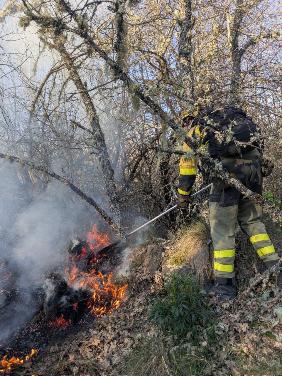 Bombero trabajando en un incendio forestal en Igüeña con llamas y humo