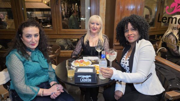 Tres mujeres disfrutando de bebidas y aperitivos en La Galería.