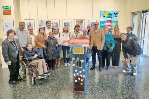 Grupo de personas en la Casa de la Cultura de Ponferrada con una obra de arte