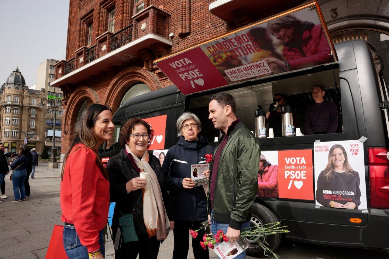 Miembros del PSOE en un acto de campaña en León con carteles y flores