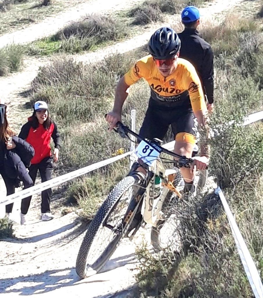 Corredor de mountain bike compitiendo en una carrera de XCO.