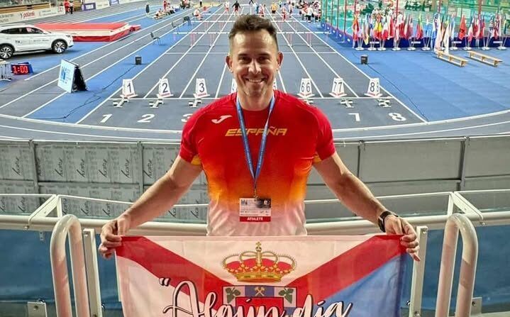 Alfredo sosteniendo una bandera en una competición de jabalina