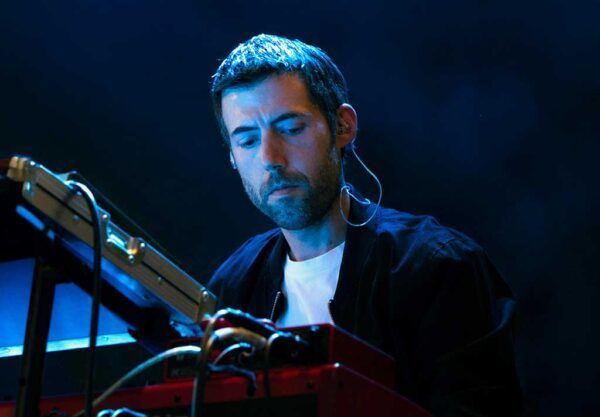 Anxo Seco tocando un teclado en un escenario iluminado