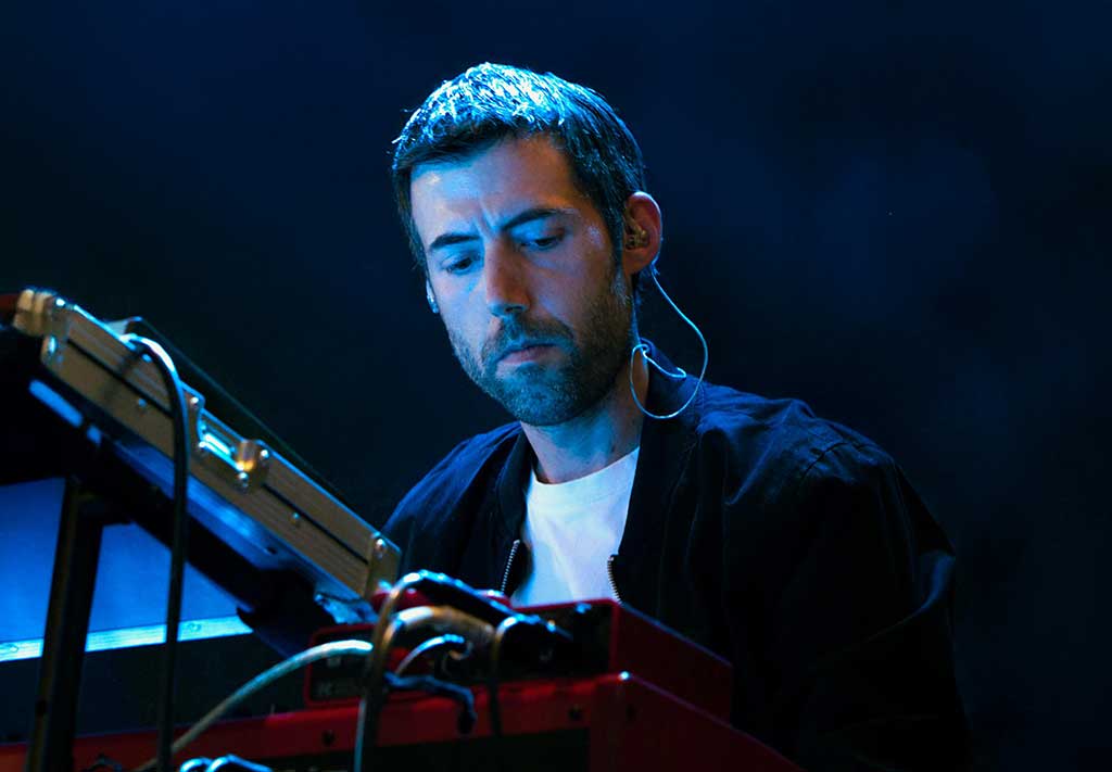 Anxo Seco tocando un teclado en un escenario iluminado