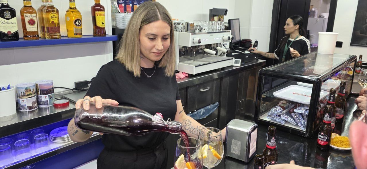 Mujer sirviendo bebida en el Bar Sueños de Ponferrada