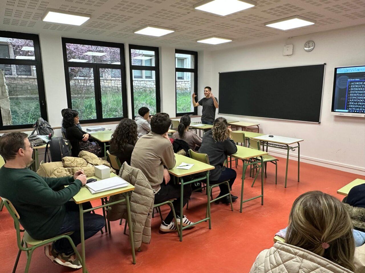 Charla sobre oposiciones en aula con participantes atentos
